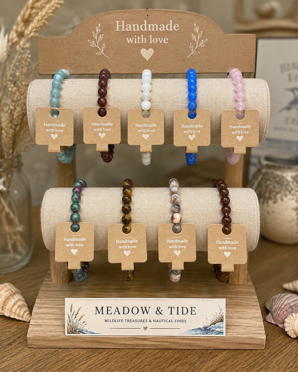 Handmade Meadow and Tide beaded bracelets on a linen stand